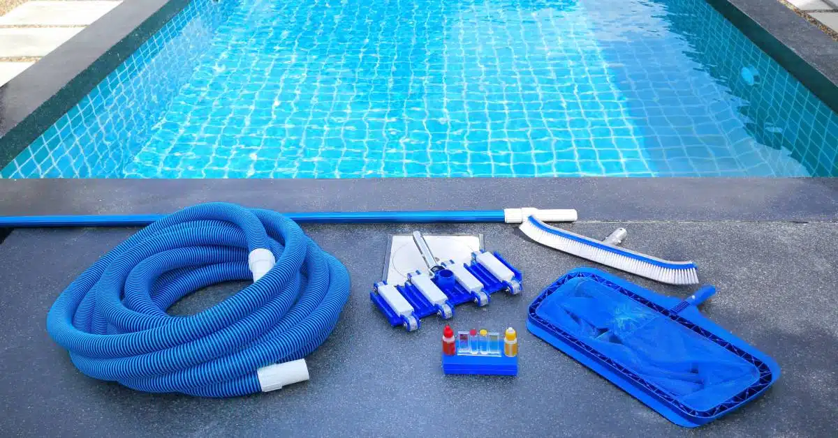 Pool chemicals and maintenance supplies sit on the concrete ground next to a small rectangular pool.